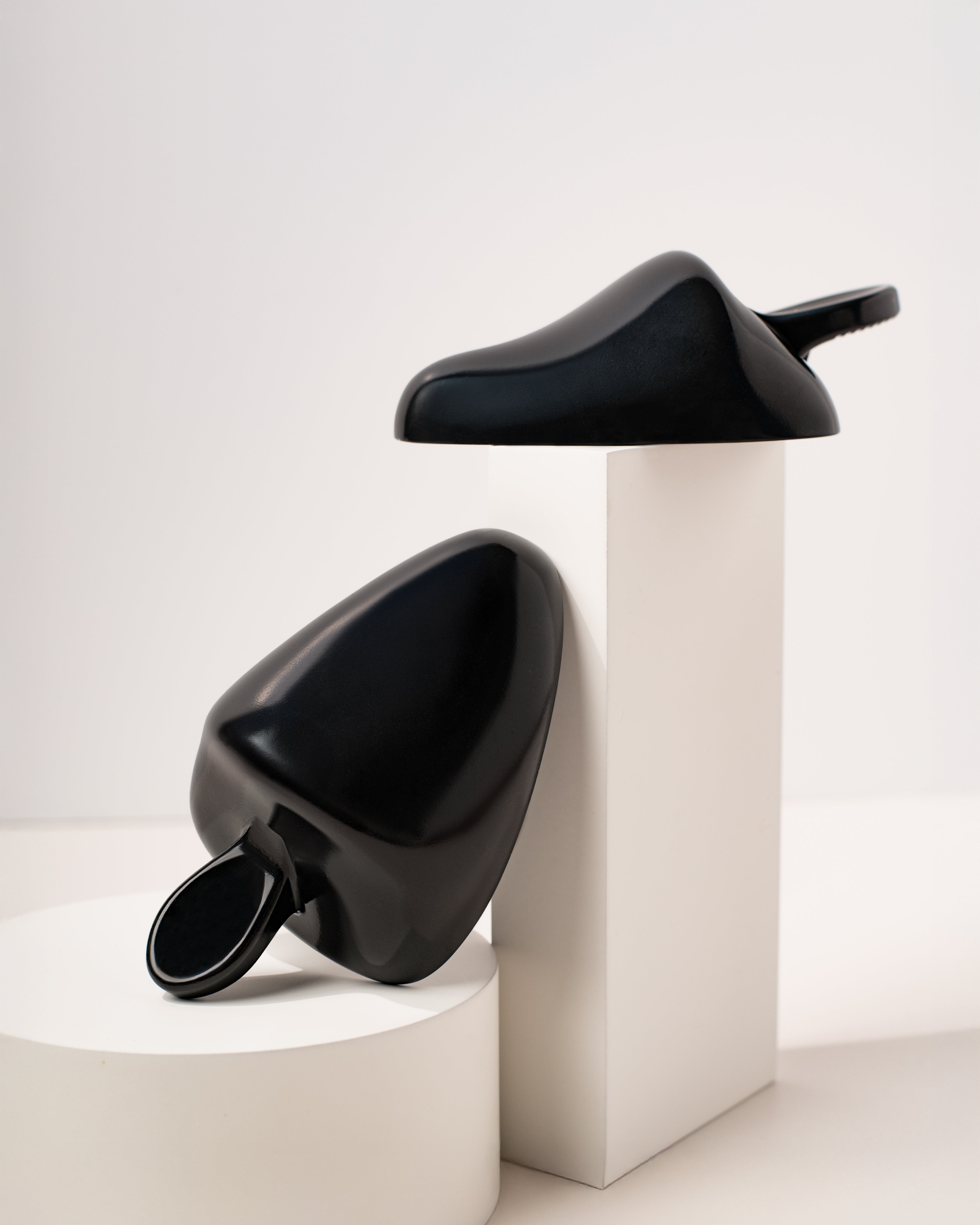 a black pair of womens shoe trees on a white display